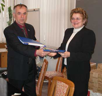 Директор МІОК та ректор МАЛіЖ обмінюються підписаними угодами.