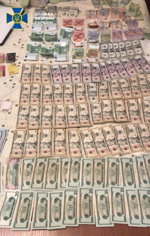 Стол усеянный деньгами, оружие и фальшивки: Полицейский помогал опасной преступной группировке 