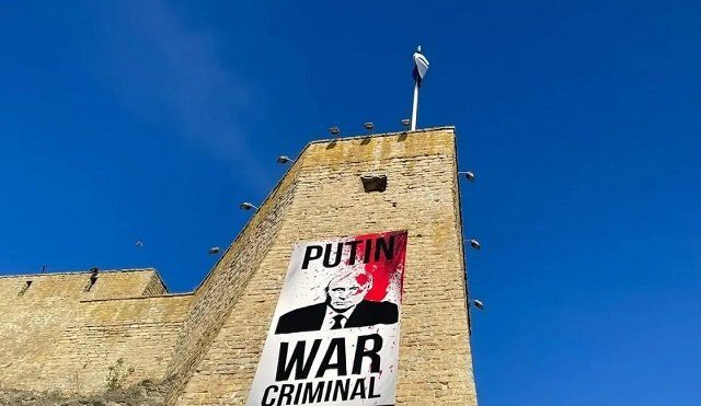 В Эстонии на границе с РФ вывесили плакат «Путин — военный преступник»