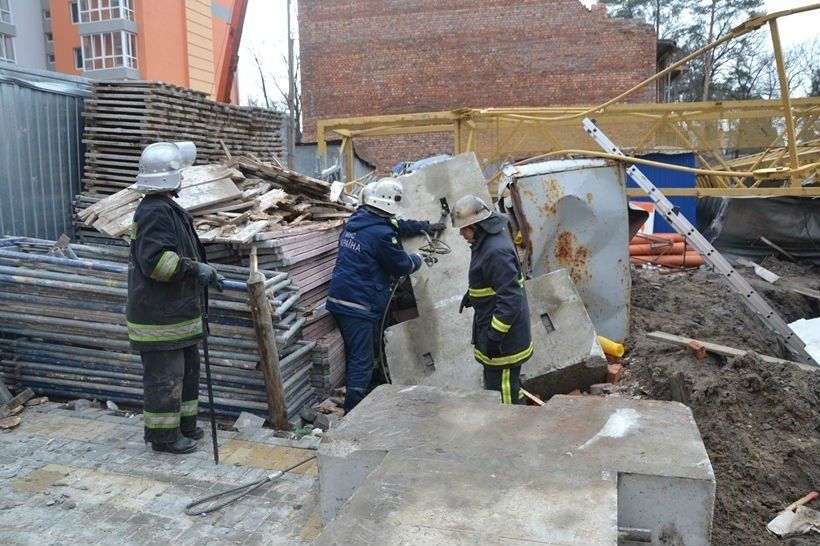 Спасатели пытаются извлечь тело погибшего из-под бетонной плиты