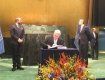 Представитель Украины при ООН Владимир Ельченко подписывает соглашение