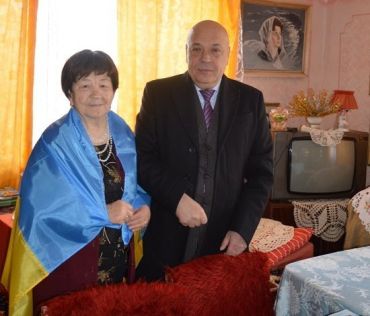 85-річна Маргарита Ткач отримала з рук губернатора національний прапор.