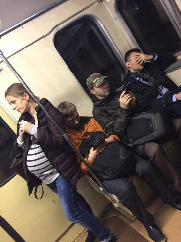 Беременная девушка стояла в вагоне метро, а возле нее сидели трое мужчин
