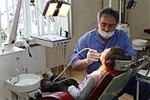 Лікар-стоматолог проводить огляд ротової порожнини дитини