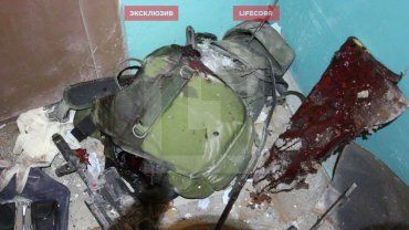 Тело погибшего боевика и его телохранителя выносят из окровавленной кабины лифта