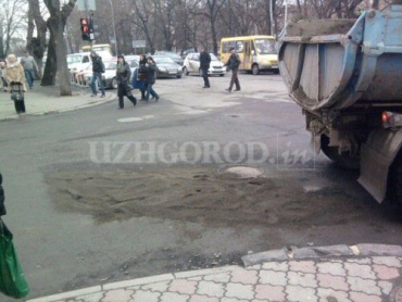 В Ужгороде глубокие ямы почти на всех улицах засыпают песком