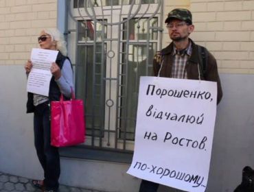 Участник митинга стоит с плакатом «Порошенко, отвали в Ростов по-хорошему»